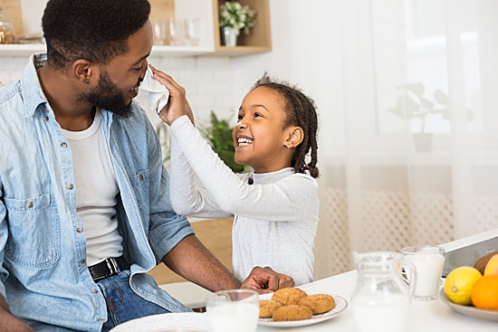Dad and daughter having fun in kitchen in cool AC